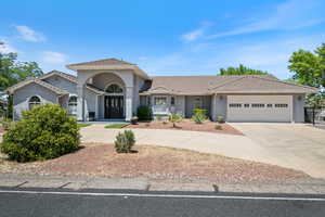View of front of home with concrete driveway, a garage, stucco siding, and a tile roof