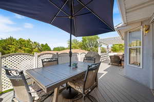 Wooden deck with outdoor dining space, a pergola, and grilling area
