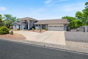 Single story home with concrete driveway, an attached garage, stucco siding, a tile roof, and a gate