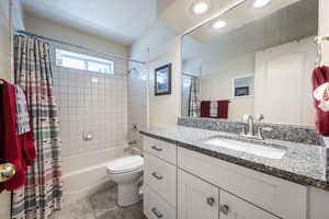 Full bathroom featuring shower / bath combo with shower curtain, vanity, and recessed lighting