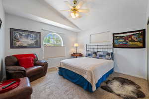 Carpeted bedroom with lofted ceiling, a ceiling fan, and a textured ceiling
