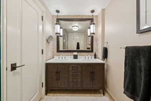 Bathroom featuring double vanity and baseboards