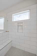 Full bath with a tile shower and tile patterned floors
