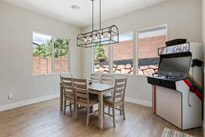 Dining area with wood finished floors and a chandelier