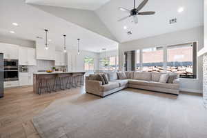 Living area with recessed lighting, ceiling fan, light wood-style floors, and high vaulted ceiling