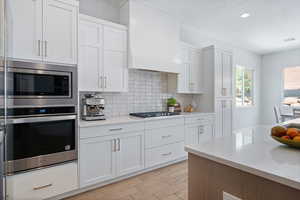 Kitchen with stainless steel appliances, light countertops, tasteful backsplash, and recessed lighting