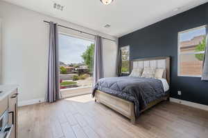 Bedroom with light wood-type flooring and multiple windows