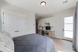 Bedroom with light wood finished floors and a closet