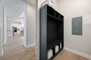 Mudroom featuring light wood-type flooring and electric panel