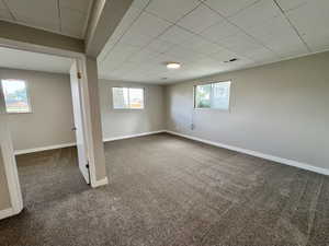 Below grade area featuring dark colored carpet and baseboards