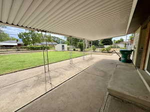 Fenced backyard featuring a patio and a storage unit
