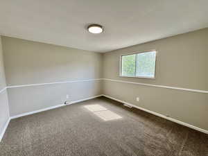 Carpeted spare room with baseboards