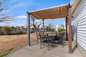 Fenced backyard featuring outdoor dining space and a patio
