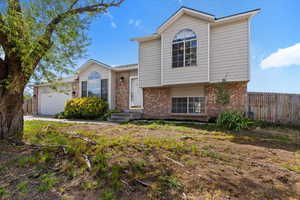 View of front of house featuring brick siding, an attached garage, and concrete driveway