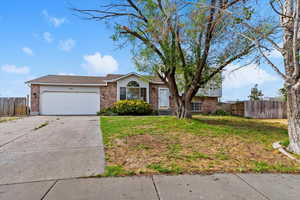 View of front of home featuring driveway, brick siding, and an attached garage