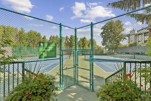 View of tennis court featuring a gate