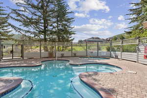 Community pool featuring a hot tub and a patio