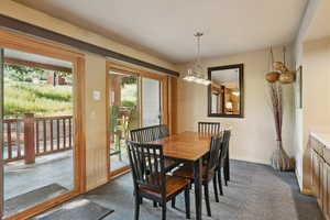 Dining room with a chandelier and dark carpet