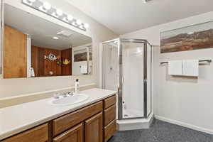 Full bath featuring a stall shower and vanity