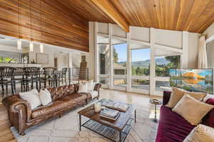 Living area featuring wooden ceiling, plenty of natural light, wood finished floors, and floor to ceiling windows