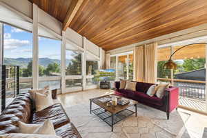 Sunroom with an outdoor hangout area, wooden ceiling, and wood finished floors