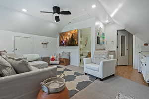 Living room with attic access, lofted ceiling, light carpet, recessed lighting, and ceiling fan