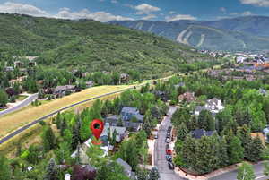 Aerial view of property's location with a mountain backdrop and nearby suburban area