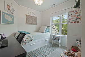 Bedroom featuring carpet floors, crown molding, and a chandelier