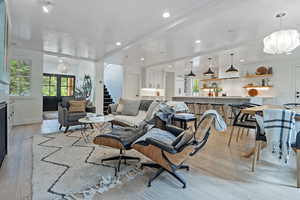 Living area featuring light wood-type flooring, stairway, recessed lighting, and a chandelier
