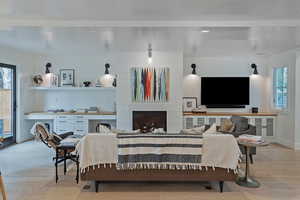 Living area featuring light wood-type flooring and a large fireplace