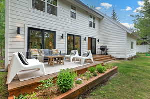 Back of property featuring an outdoor hangout area, a deck, and a yard