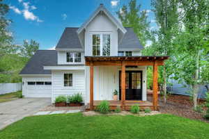 Modern farmhouse style home with roof with shingles, board and batten siding, concrete driveway, an attached garage, and a porch