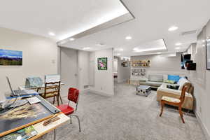 Office space with light colored carpet and recessed lighting