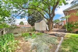 Fenced backyard with a shed and stairway