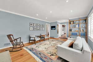 Living room featuring recessed lighting, crown molding, and wood finished floors