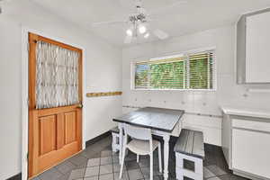 Dining area featuring tile patterned floors and a ceiling fan