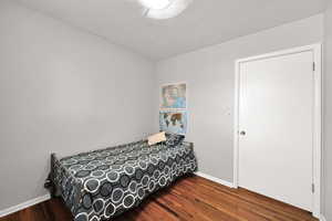 Bedroom with wood finished floors and baseboards