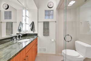 Bathroom with tile patterned floors, vanity, and a shower stall