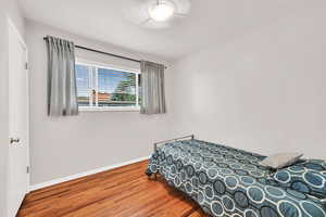 Bedroom with wood finished floors and baseboards
