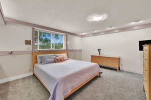 Bedroom with carpet and a textured ceiling