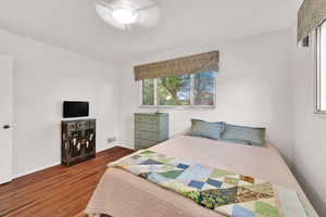 Bedroom with wood finished floors and baseboards