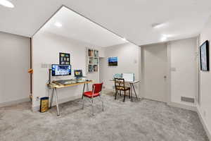 Carpeted office space with built in features and recessed lighting