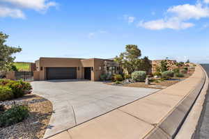 Adobe home with a garage, stucco siding, and concrete driveway