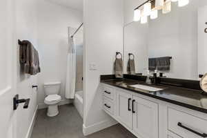 Full bath with vanity, tile patterned floors, and shower / tub combo