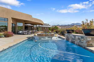 View of swimming pool with a patio, a mountain view, and a pool with connected hot tub