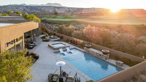 View of pool featuring a mountain view, a patio, an in-ground hot tub, and golf course view