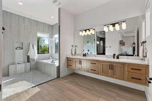 Bathroom with a garden tub, double vanity, walk in shower, and recessed lighting