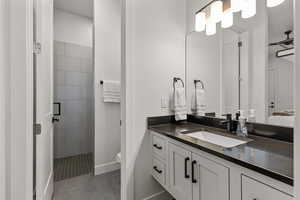 Full bathroom featuring tile patterned flooring, vanity, a tile shower, and ensuite bathroom