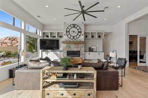 Living area featuring a ceiling fan, hardwood / wood-style floors, recessed lighting, and a fireplace