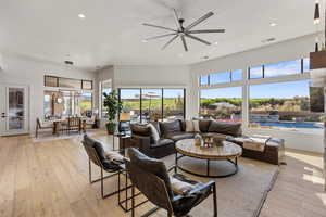 Living room with light wood finished floors, ceiling fan, recessed lighting, and a textured ceiling